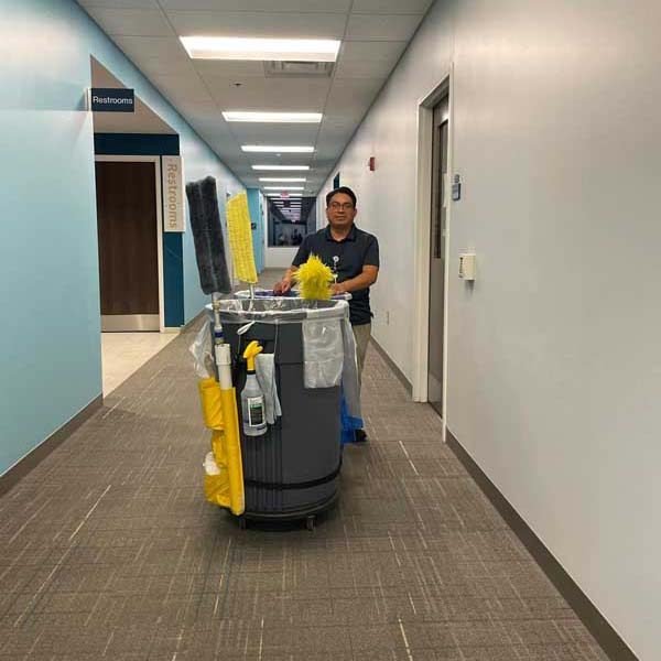 A Starbiz janitorial team member with a cleaning cart in a metro Atlanta facility corridor