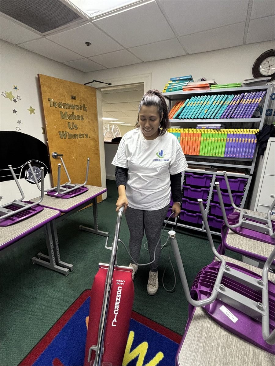 Starbiz cleaner vacuuming a school gym